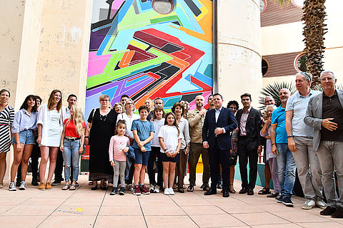 Le maire, Frédéric Masquelier, en compagnie des contributeurs du festival, au pied de la fresque réalisée par l'artiste Lokiss, à sa gauche.