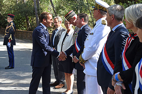 Le président Macron saluant Frédéric Masquelier, en présence du président Nicolas Sarkozy.