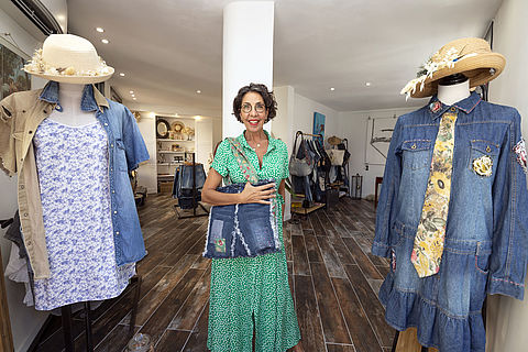 Agnès peésente l'une de ses création, un sac en jeans, au sein de sa boutique